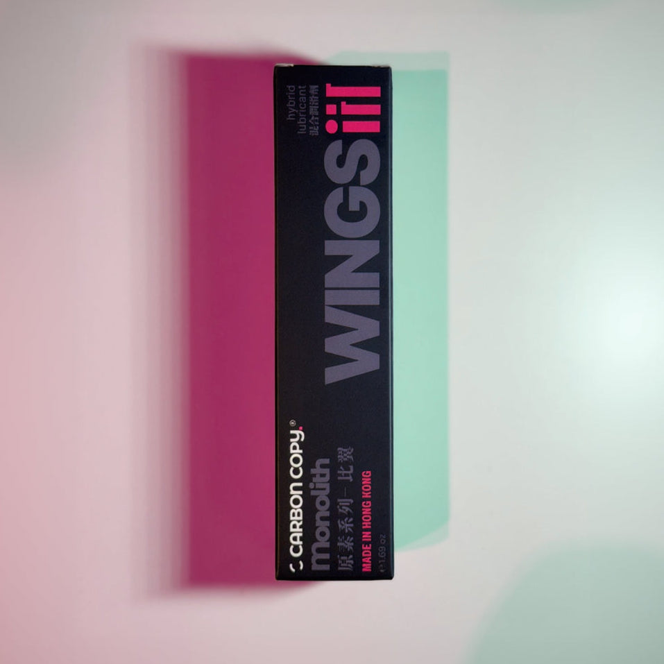 Black box with 'WINGS III' branding on a pink and green gradient background